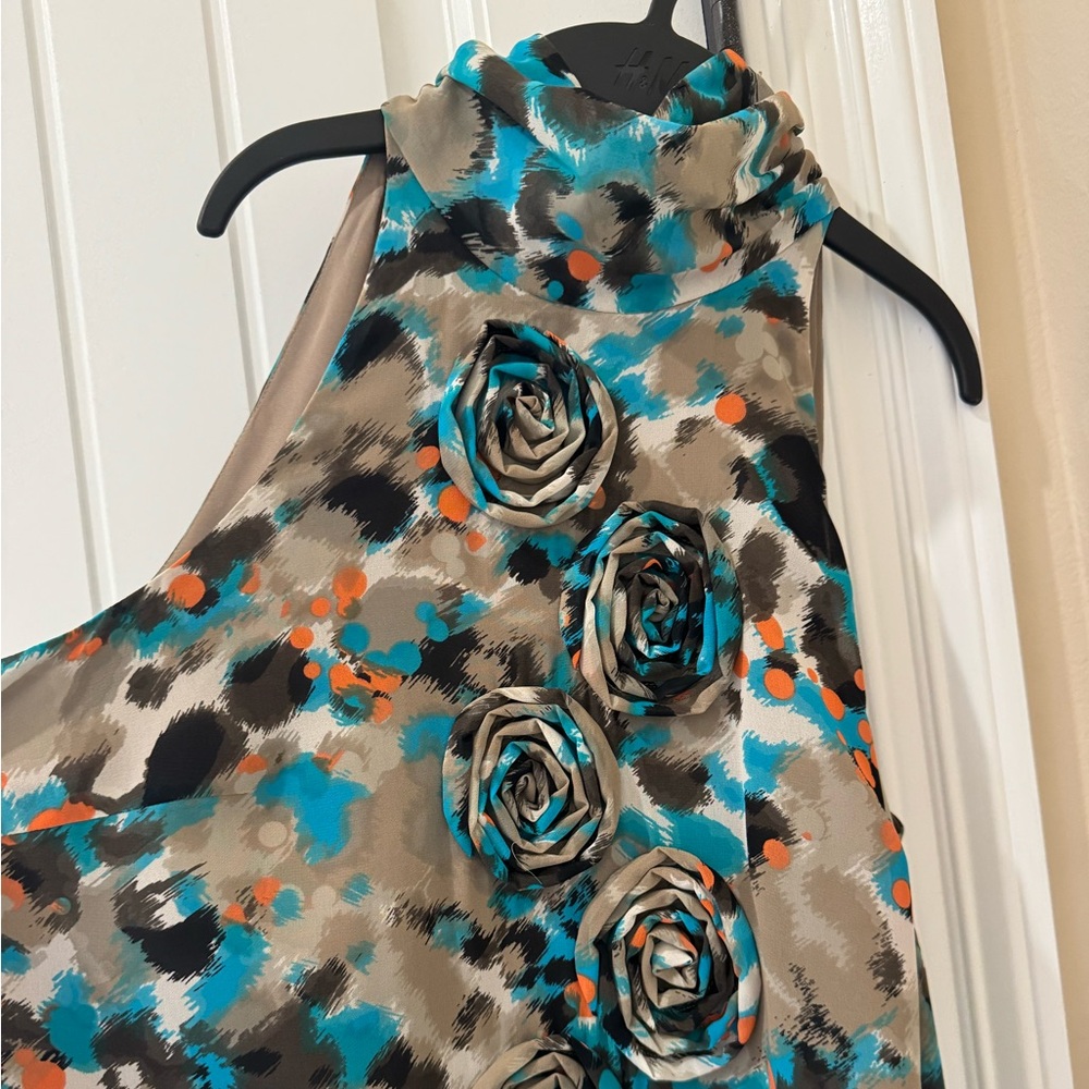 Cute details Kenzie dress. With rosettes, ruffle bottom and a high neck.